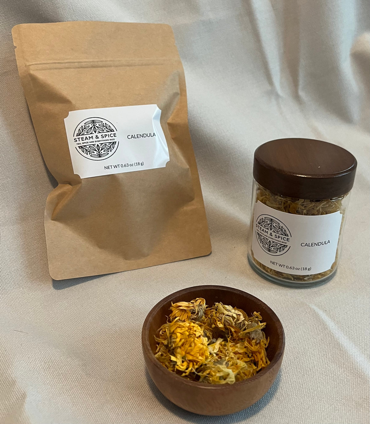Loose Calendula Flowers in Wooden bowl, glass jar and Kraft Brown Refill Pouch