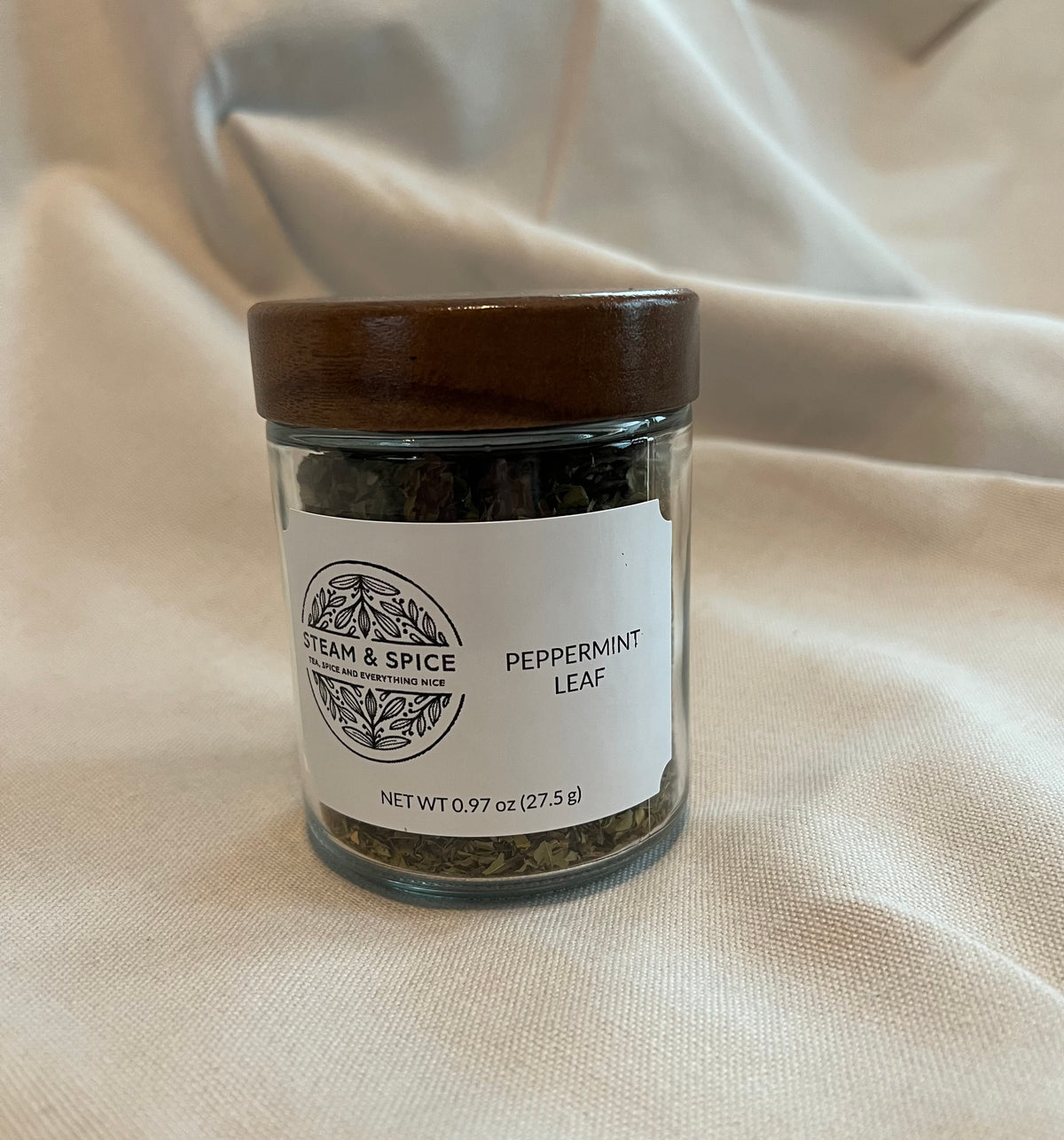 Peppermint Leaf in a glass jar with a wooden acacia lid