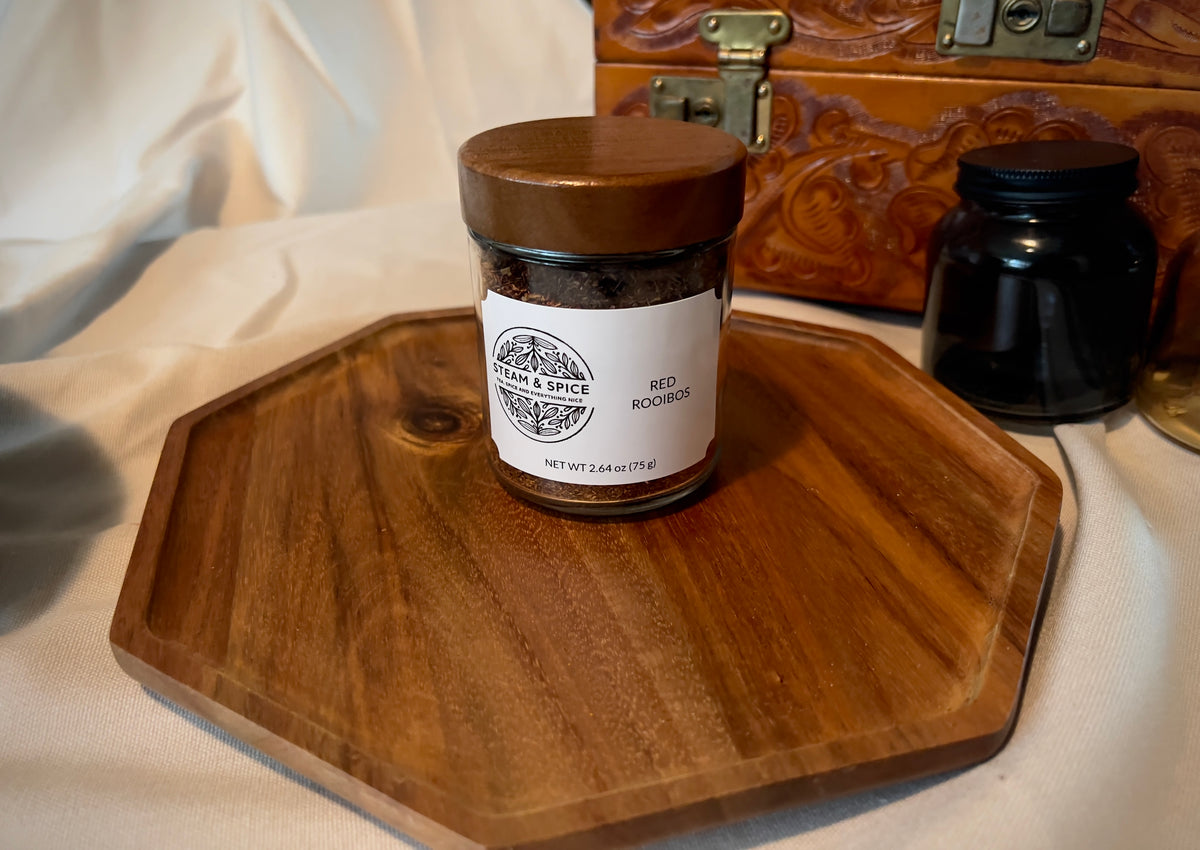 A glass jar of Red Roarings with a brown wooden lid and a white label, displayed on an octagonal wooden tray.